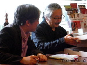 Nobuo Uematsu & Masashi Hamauzu schauen sich die zur Signatur vorgelegten Schätze genau an
